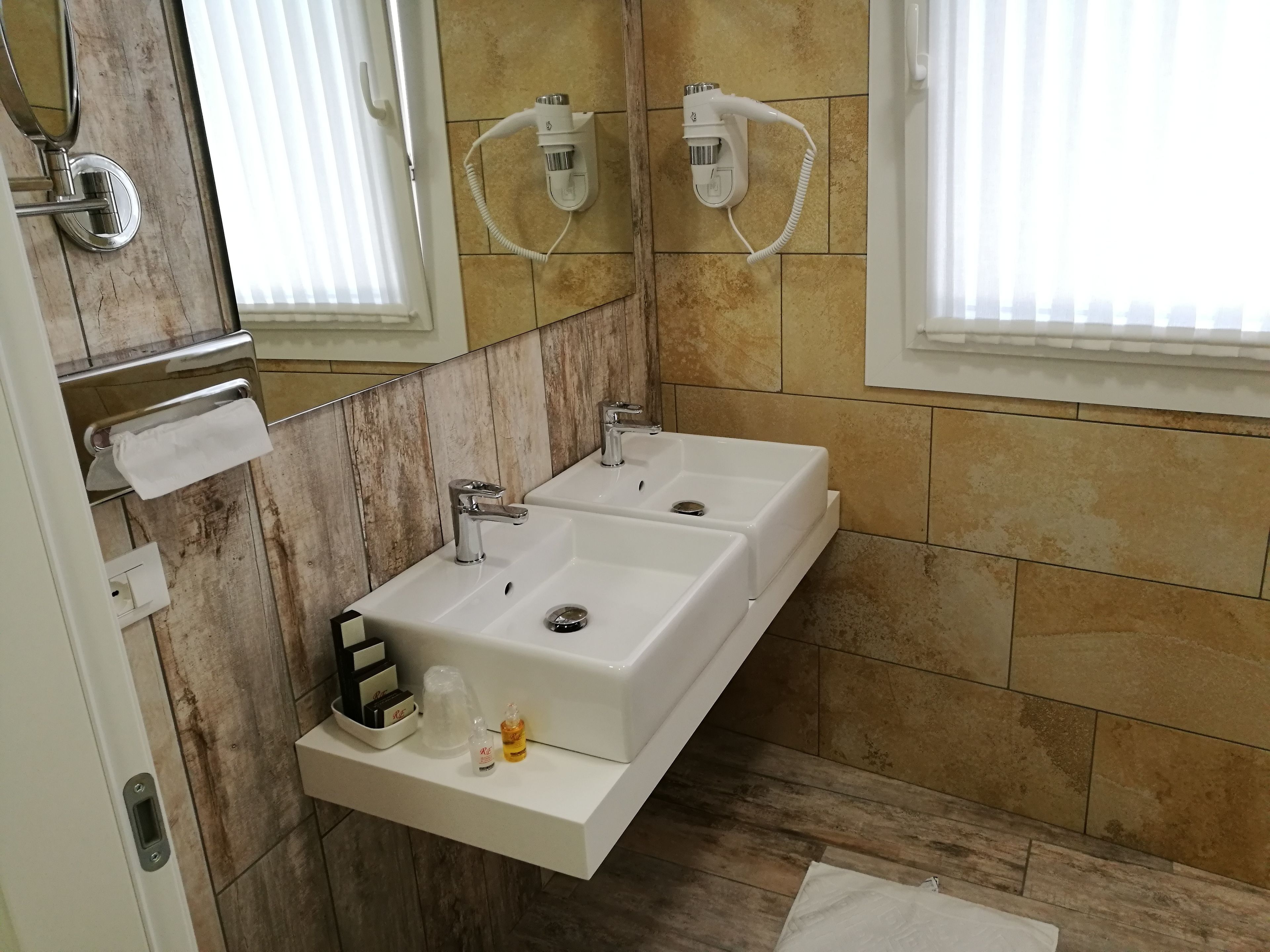 Un baño con dos lavamanos, un perchero y un espejo.