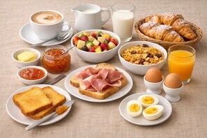 Un desayuno con tostadas, huevos, cruasanes y diferentes mermeladas y acompañamientos.