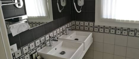 A bathroom with two sinks, a mirror, and a towel rack.