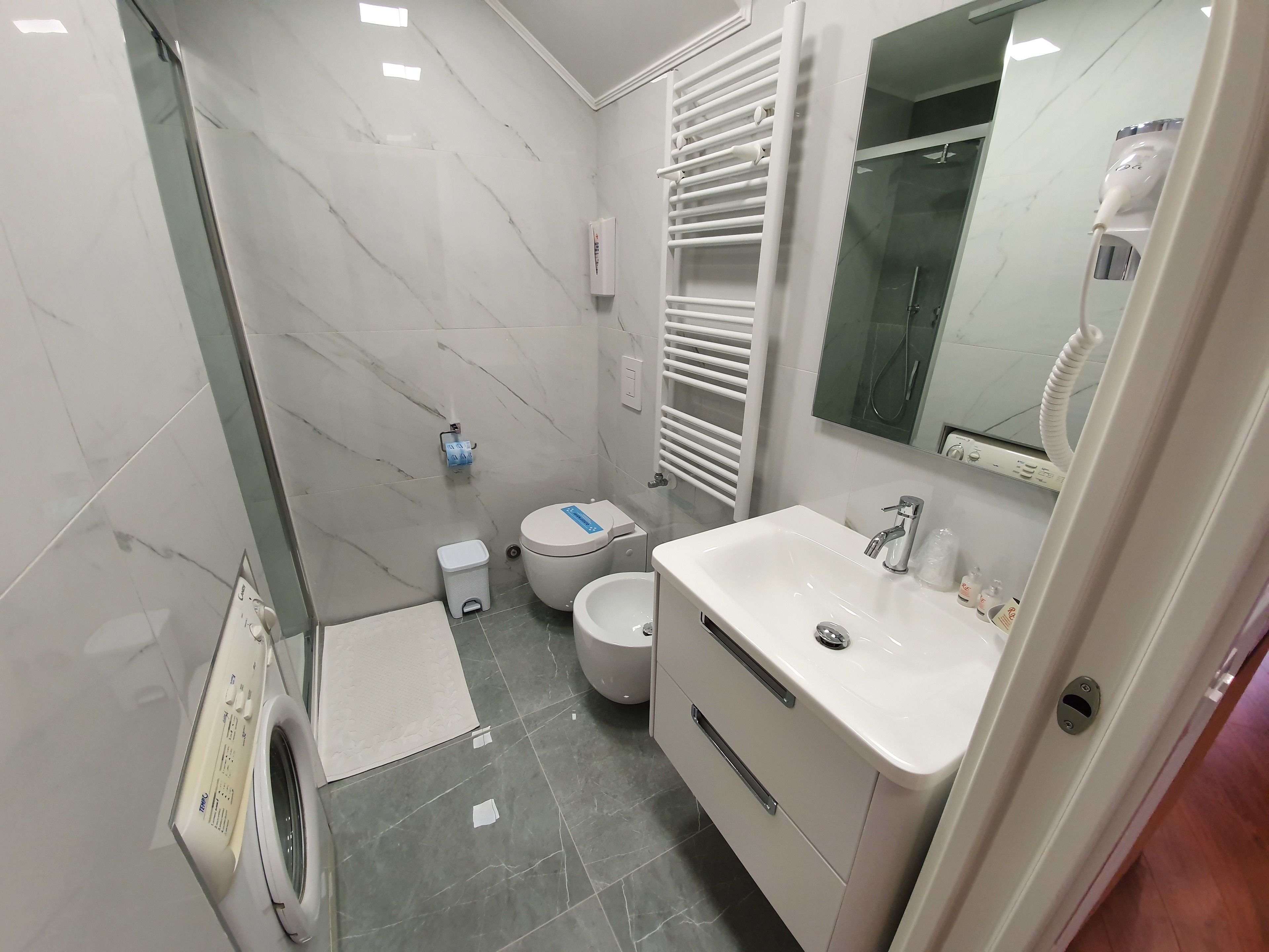 Ein modernes Badezimmer mit Toilette, Waschbecken und Dusche.