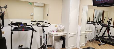 A fitness room with treadmills, a stepper, and a bench.