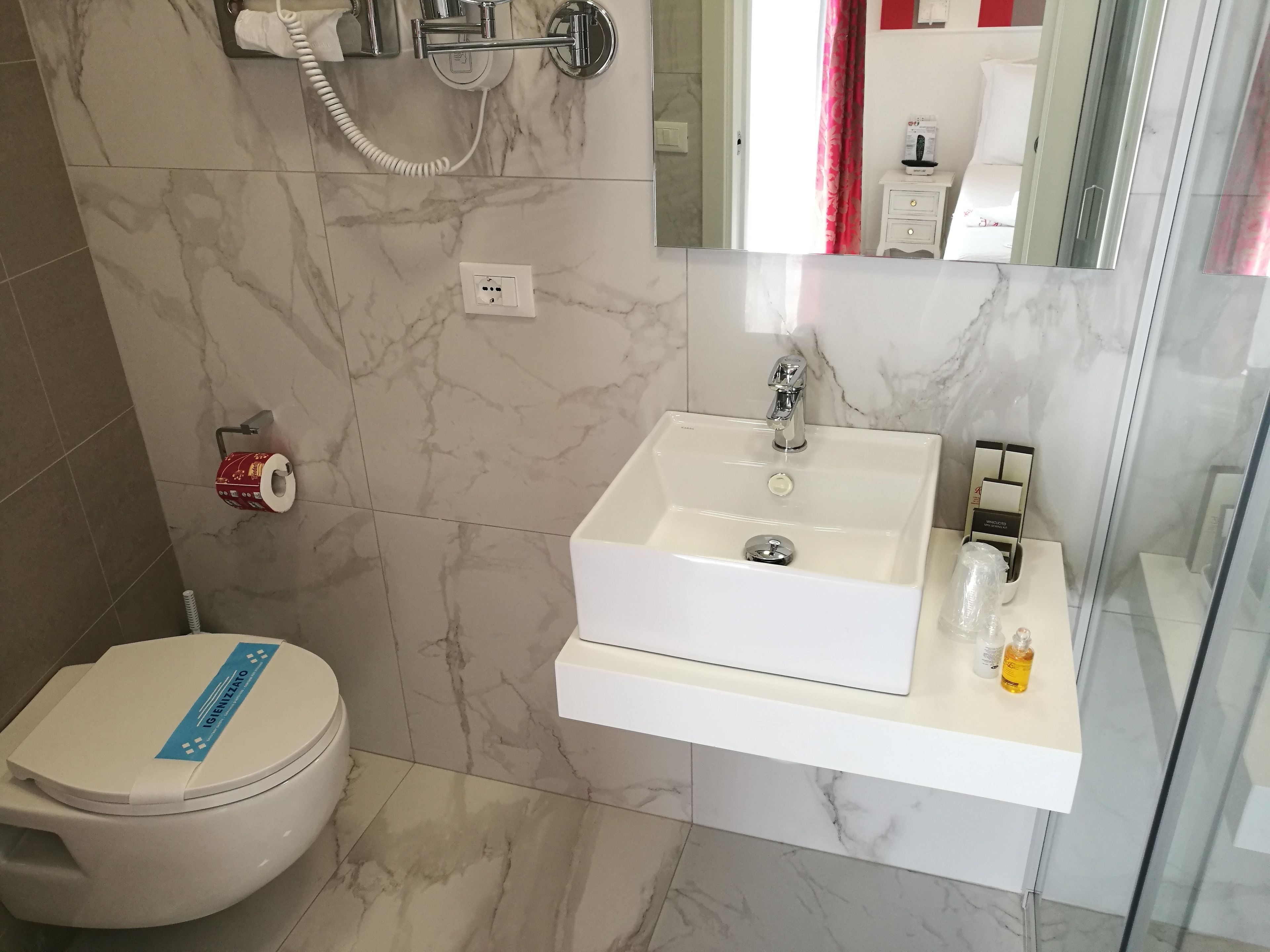 A bathroom with a white sink, a toilet, and a shower area.