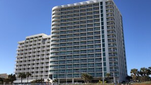 Un hotel de varios pisos con un diseño moderno, que cuenta con balcones en cada planta.