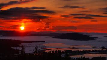 A sunset over a lake with mountains in the background.