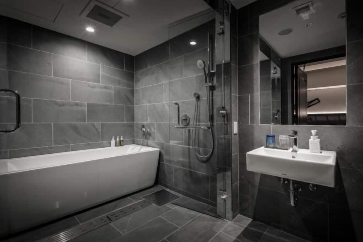 Badkamer | Een bad/douchecombinatie, gratis toiletartikelen, een haardroger