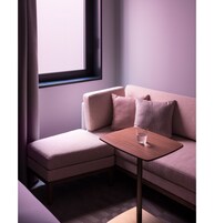 Uma sala de estar moderna com um sofá, uma mesinha e um copo de água.