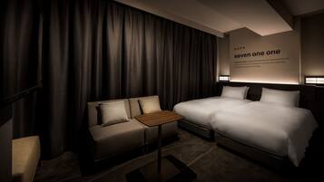 Ein Hotelzimmer mit Bett, einer Couch, einem kleinen Tisch und einer Wand mit Text.
