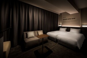 Ein Hotelzimmer mit Bett, einer Couch, einem kleinen Tisch und einer Wand mit Text.