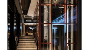 A modern interior with a staircase, glass partitions, and a metallic elevator. - BESPOKE HOTEL Shinjuku (Tokyo)