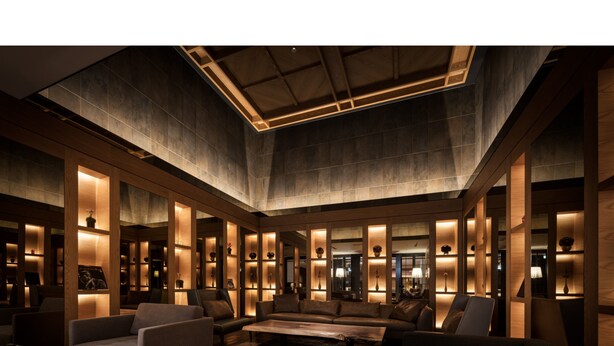 A spacious lobby with a high ceiling, wooden paneling, and modern furnishings including sofas and a coffee table. - BESPOKE HOTEL Shinjuku (Tokyo)