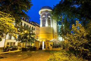 Vista frontal de la propiedad por la tarde o noche