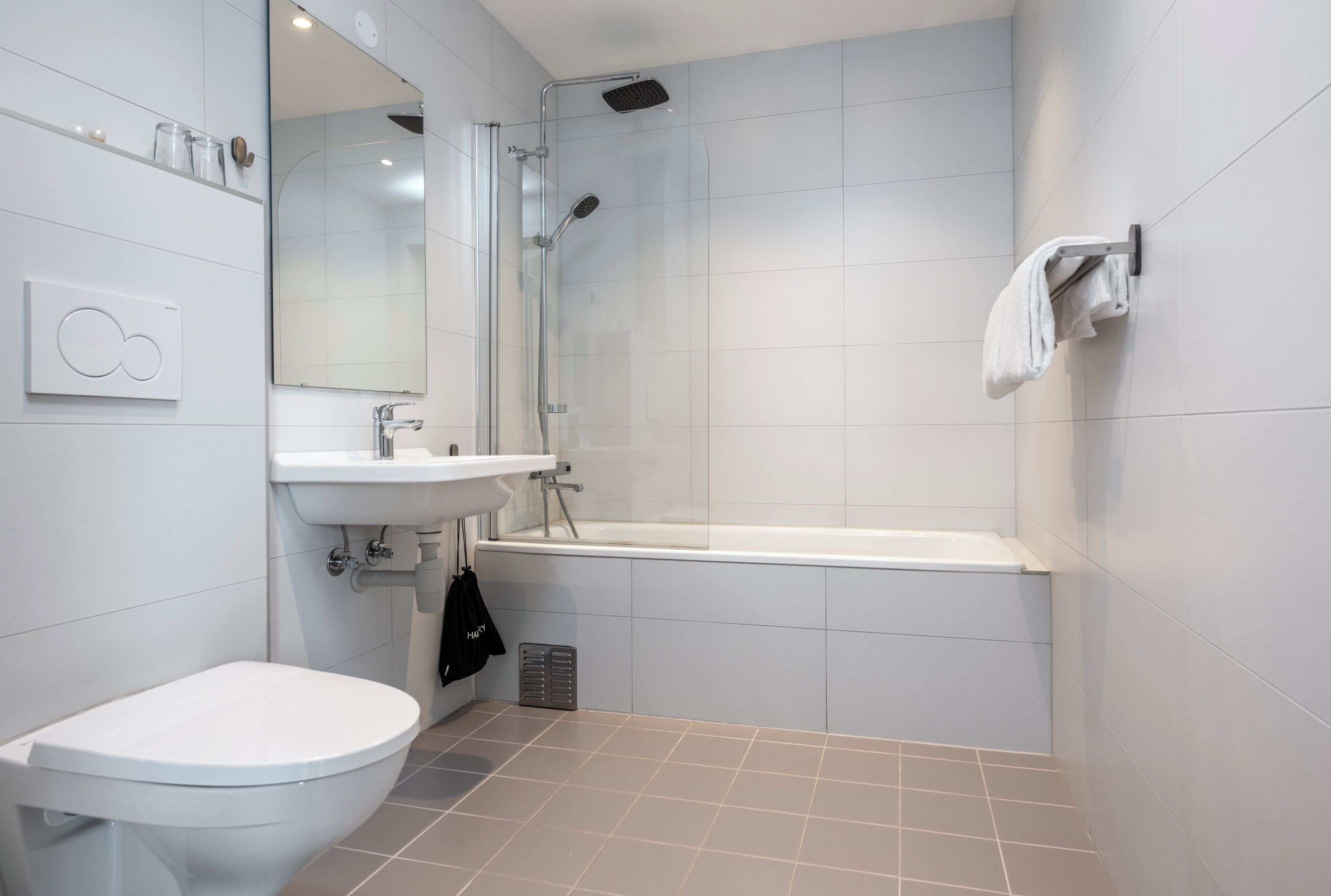 A modern bathroom with a toilet, sink, shower, and bathtub.
