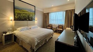 A hotel room with a large bed, a desk, a chair, a TV, and a painting on the wall. - Baiyun Hotel Xinchang (SHAOXING)
