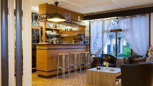 Een bar met krukken, een toonbank met flessen en uitzicht door dunne gordijnen.