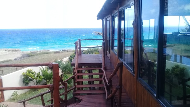 A wooden deck with a view of the ocean. - C-Mew Guesthouse (Inhambane)