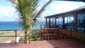 A wooden deck with a pool, overlooking the ocean. - C-Mew Guesthouse (Inhambane)