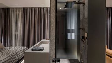 A modern bathroom with a glass shower enclosure, a built-in sink, and a vanity with a towel.