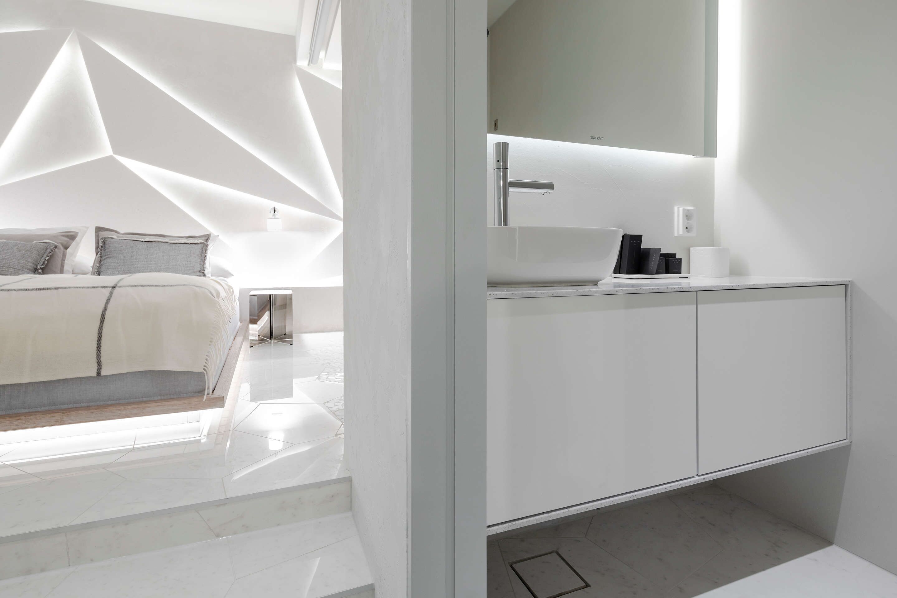 Una camera da letto moderna con un letto, un comodino e un grande specchio.