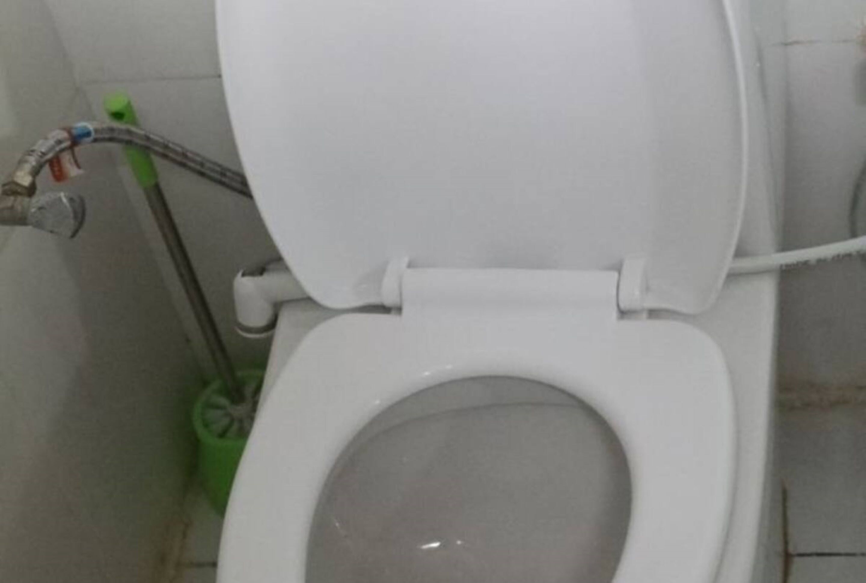 A white toilet with a closed seat in a bathroom.
