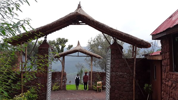 Un arco de piedra con techo de paja que da paso a un edificio.