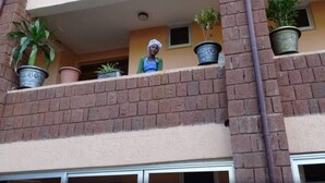 A balcony with potted plants and a person standing on it.