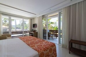 A hotel room with a bed, a desk, a television, and a balcony with a table and chairs. - Jatiuca Resort (MACEIO)