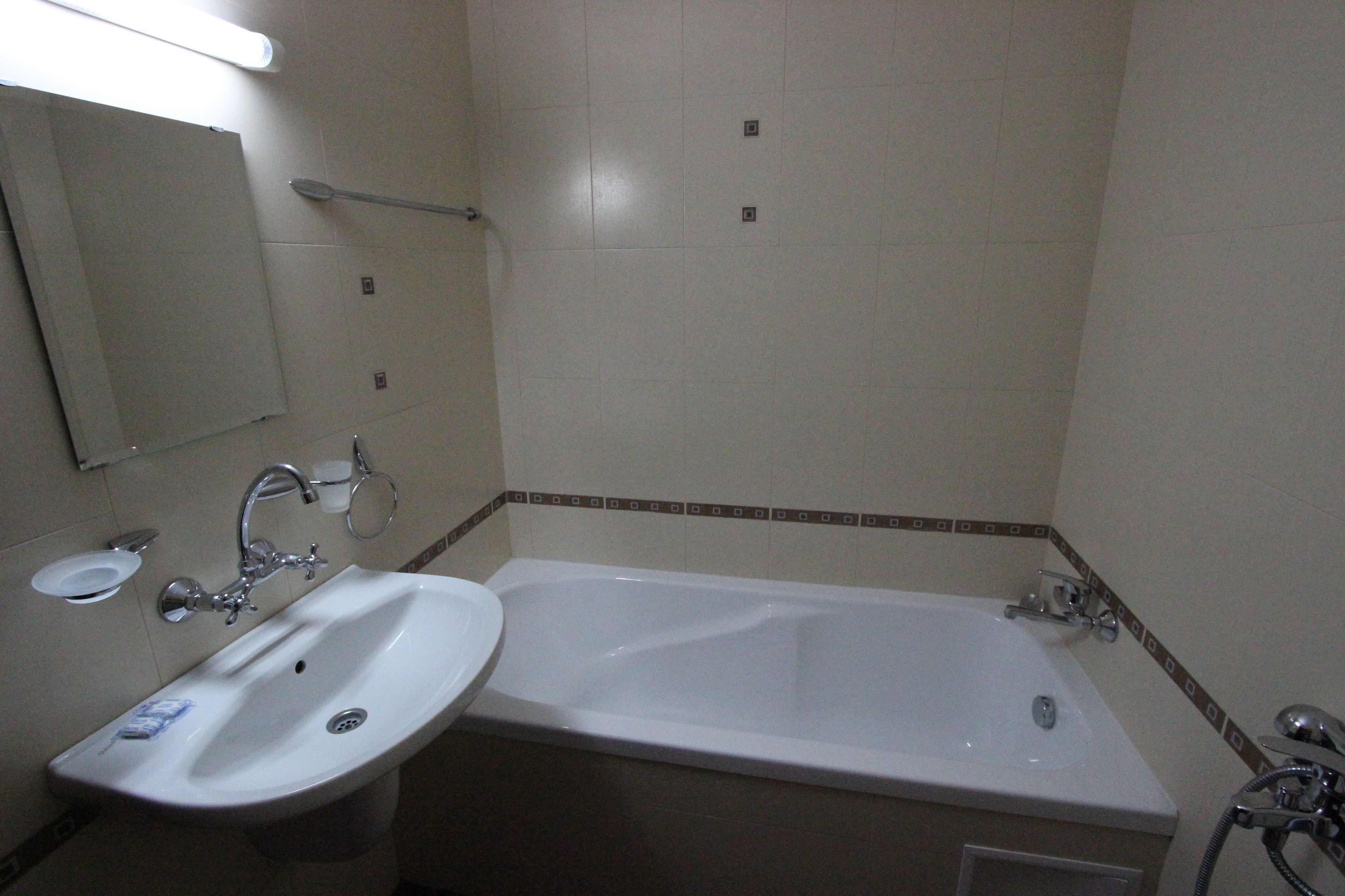 Un baño con lavamanos, espejo y bañera.