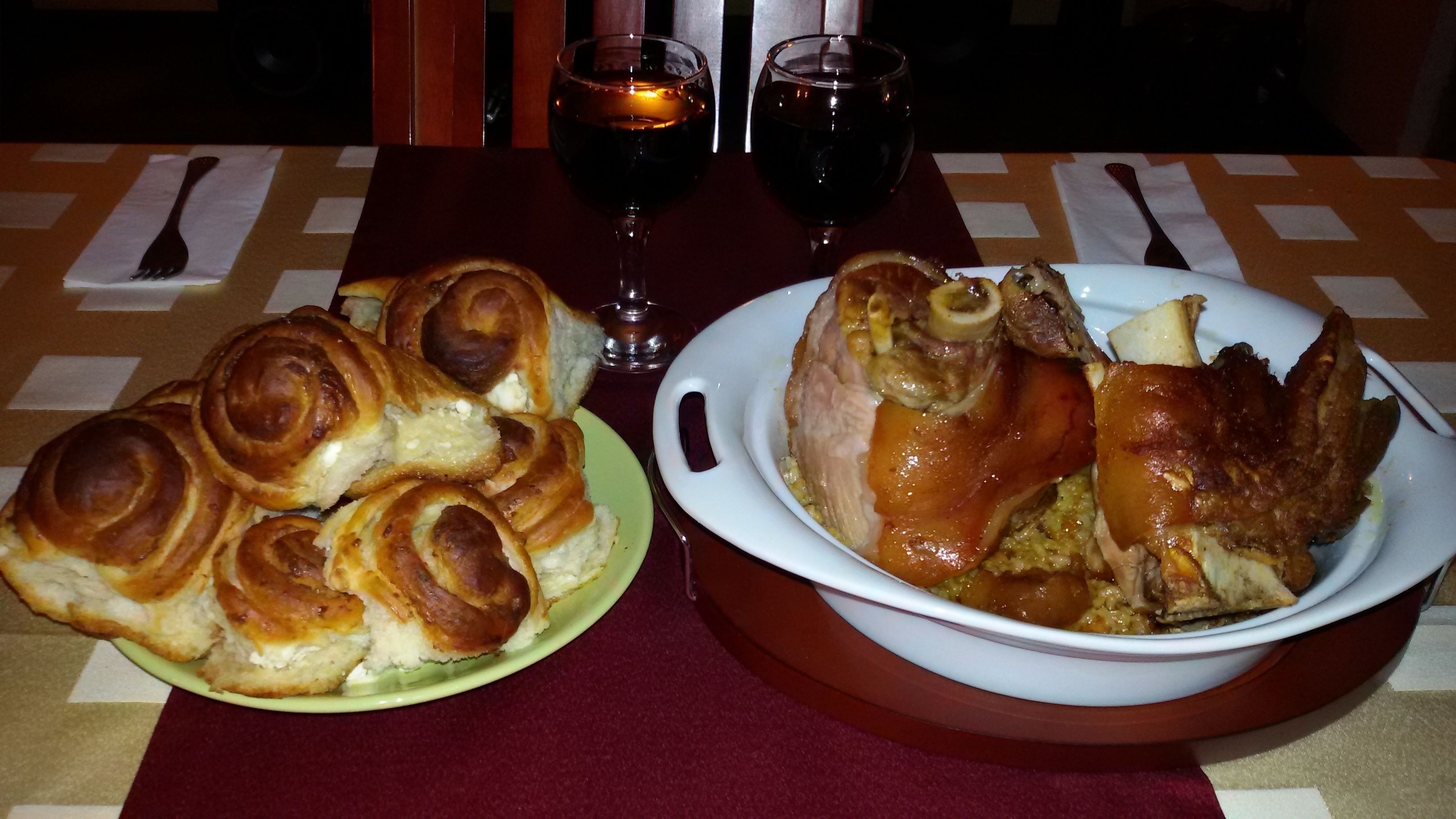 A table with a plate of pastries and a bowl of roasted meat.