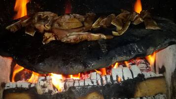 Un horno de leña tradicional con comida cocinándose en su interior.