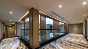 A modern hotel lobby with a glass partition, a patterned carpet, and a clean, minimalist design. - Boudl Al Corniche (Dammam)