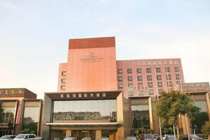 A multi-story building with signage indicating it is a hotel. - Danube International Hotel (Qingdao)