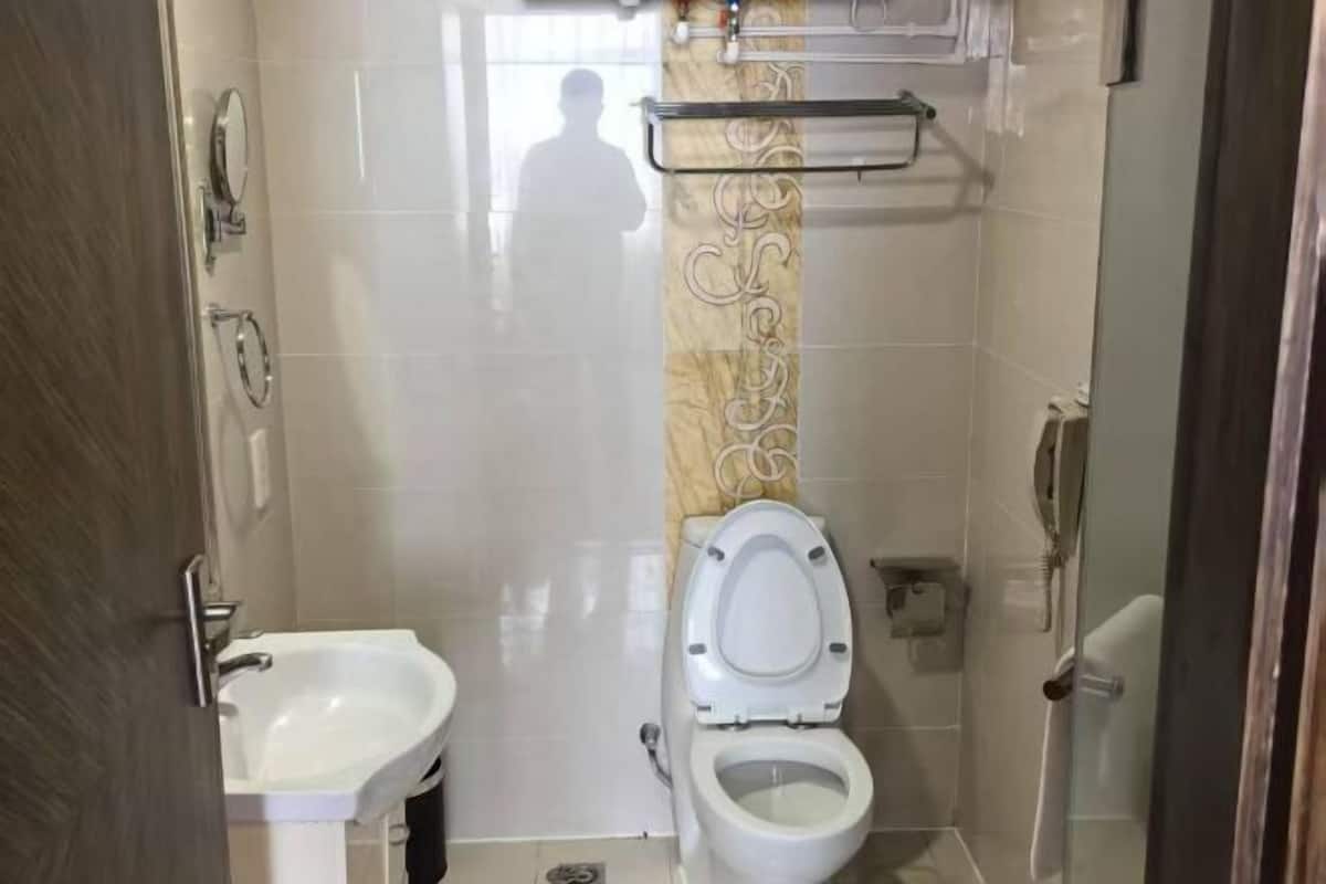 A bathroom with a toilet, sink, and a shower area.