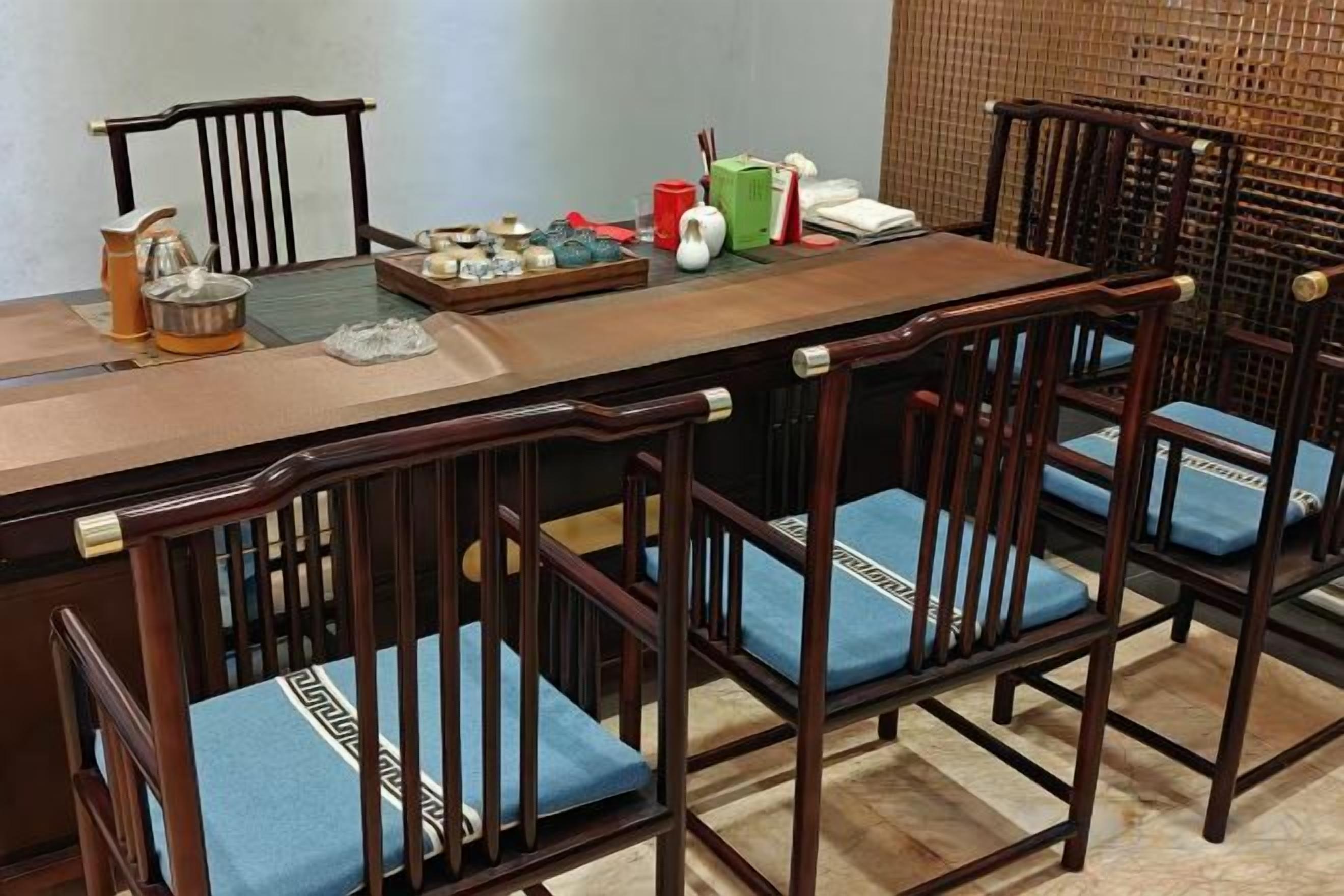 Un comedor con una larga mesa de madera y seis sillas de madera con cojines azules.