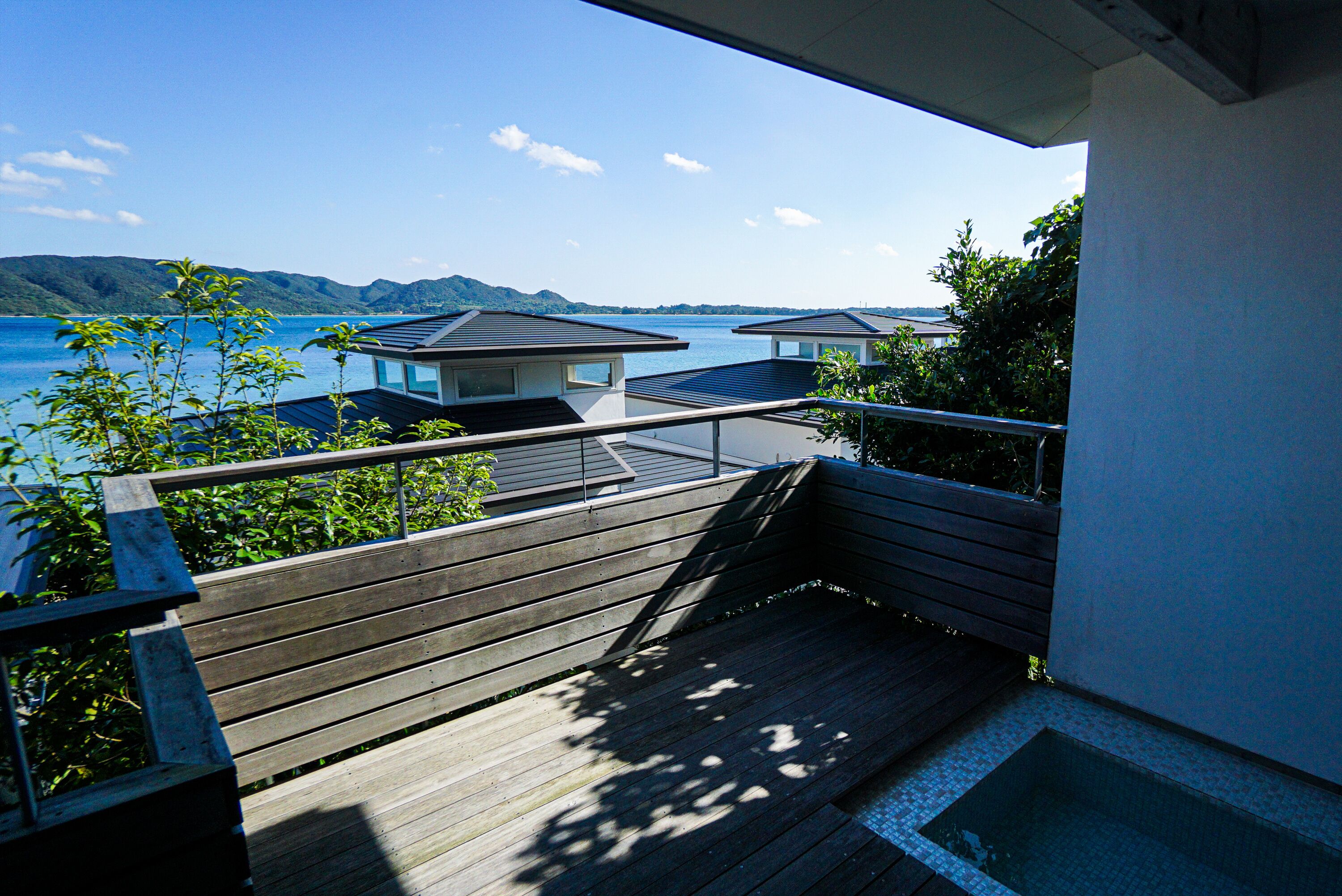 A wooden deck with a view of a lake and mountains.