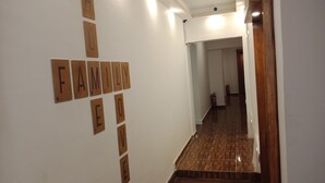 Un couloir doté d’un plancher en bois et d’un mur sur lequel sont disposées des lettres formant les mots « AMOUR FAMILIAL ».