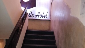 Un escalier menant à une pièce sur laquelle est apposée une enseigne indiquant « Hôtel ».