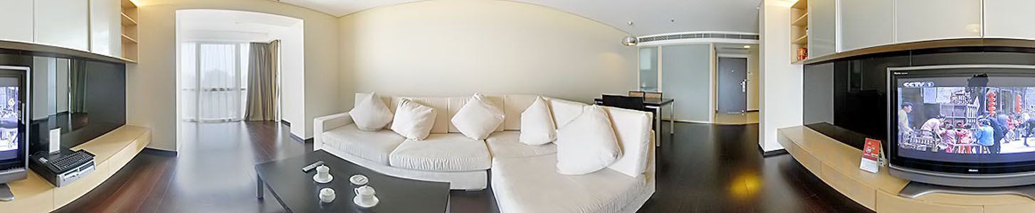 Una sala de estar moderna con un sofá curvo, un televisor de pantalla plana y una mesa de centro.
