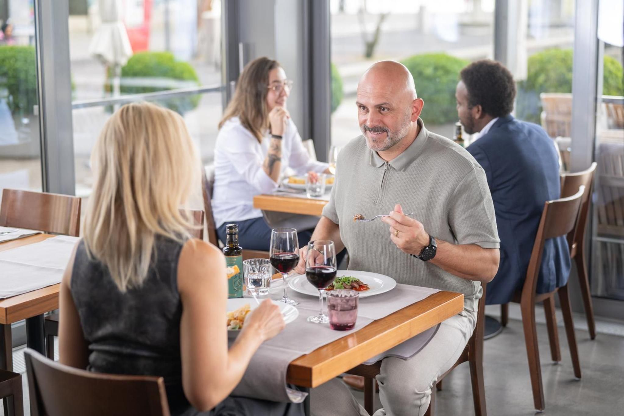 Un restaurante con mesas, sillas y comensales.