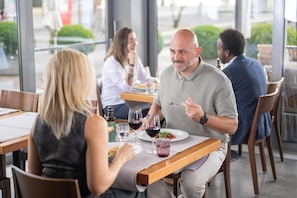 Un restaurante con mesas, sillas y comensales.