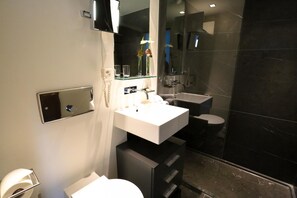 A modern bathroom with a white sink, a mirror, and a glass shower enclosure. - Marina Lachen (Lachen)