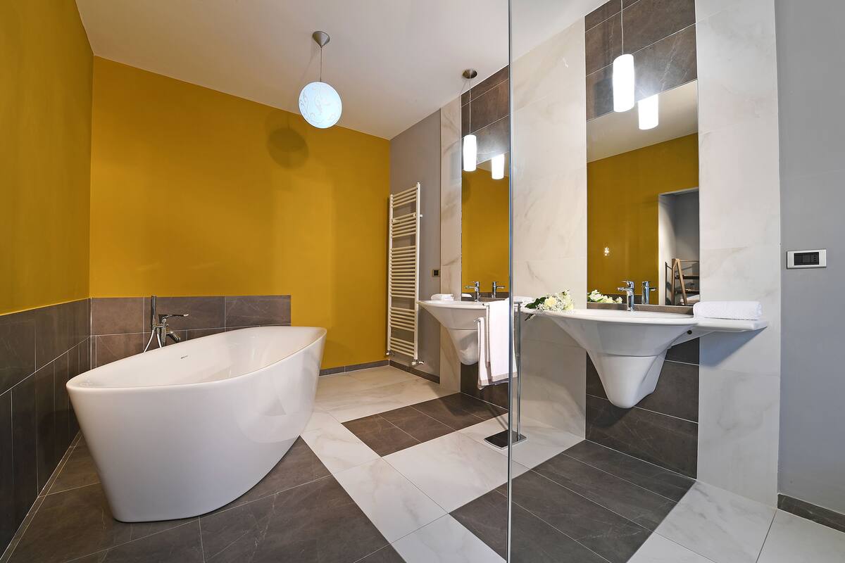 A modern bathroom with a freestanding bathtub, a vanity with a sink, and a large mirror.