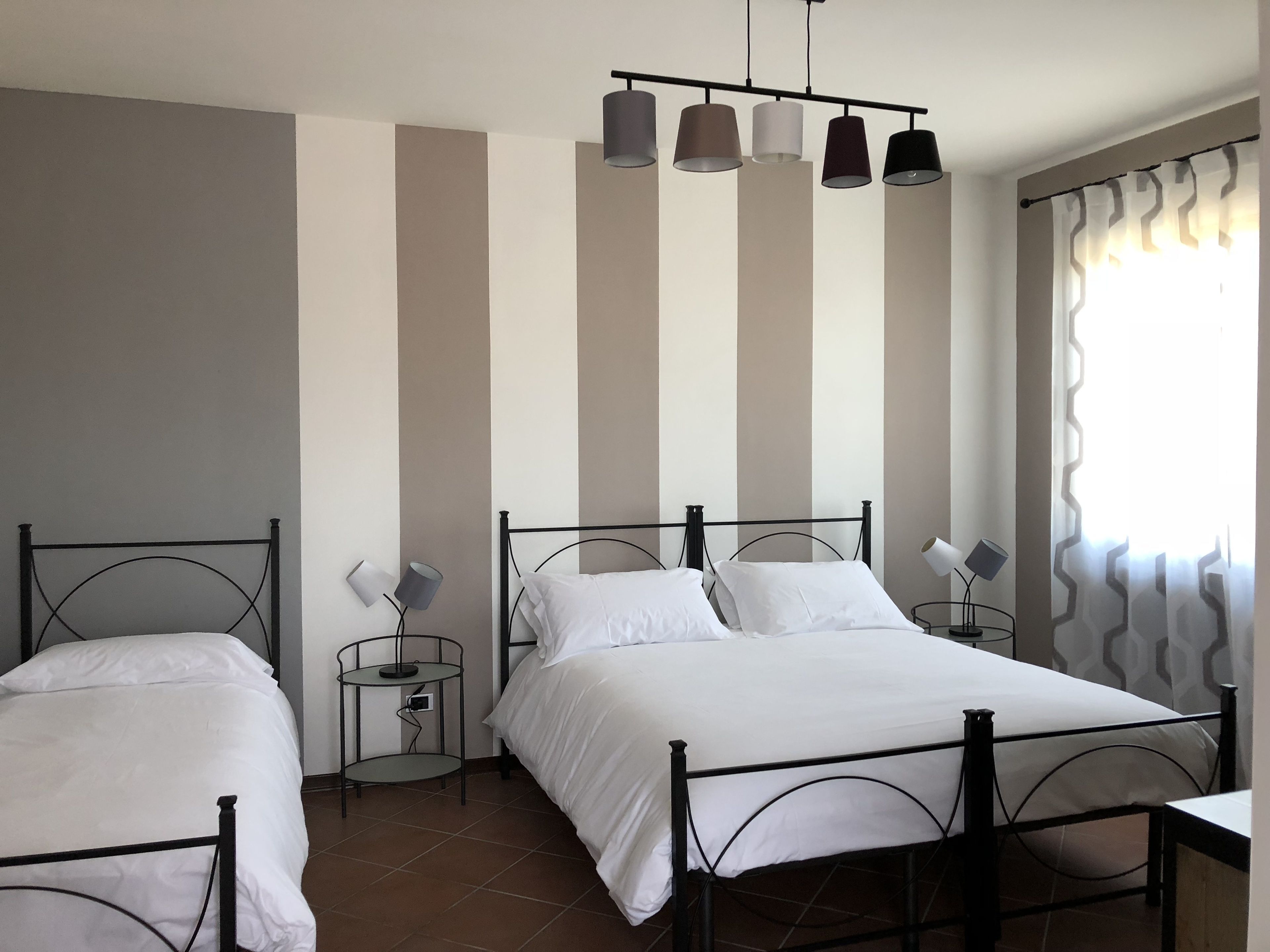 Ein Zimmer mit zwei Betten, einem kleinen Tisch und einer Lampe.