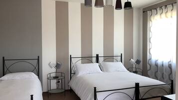 Ein Zimmer mit zwei Betten, einem kleinen Tisch und einer Lampe.