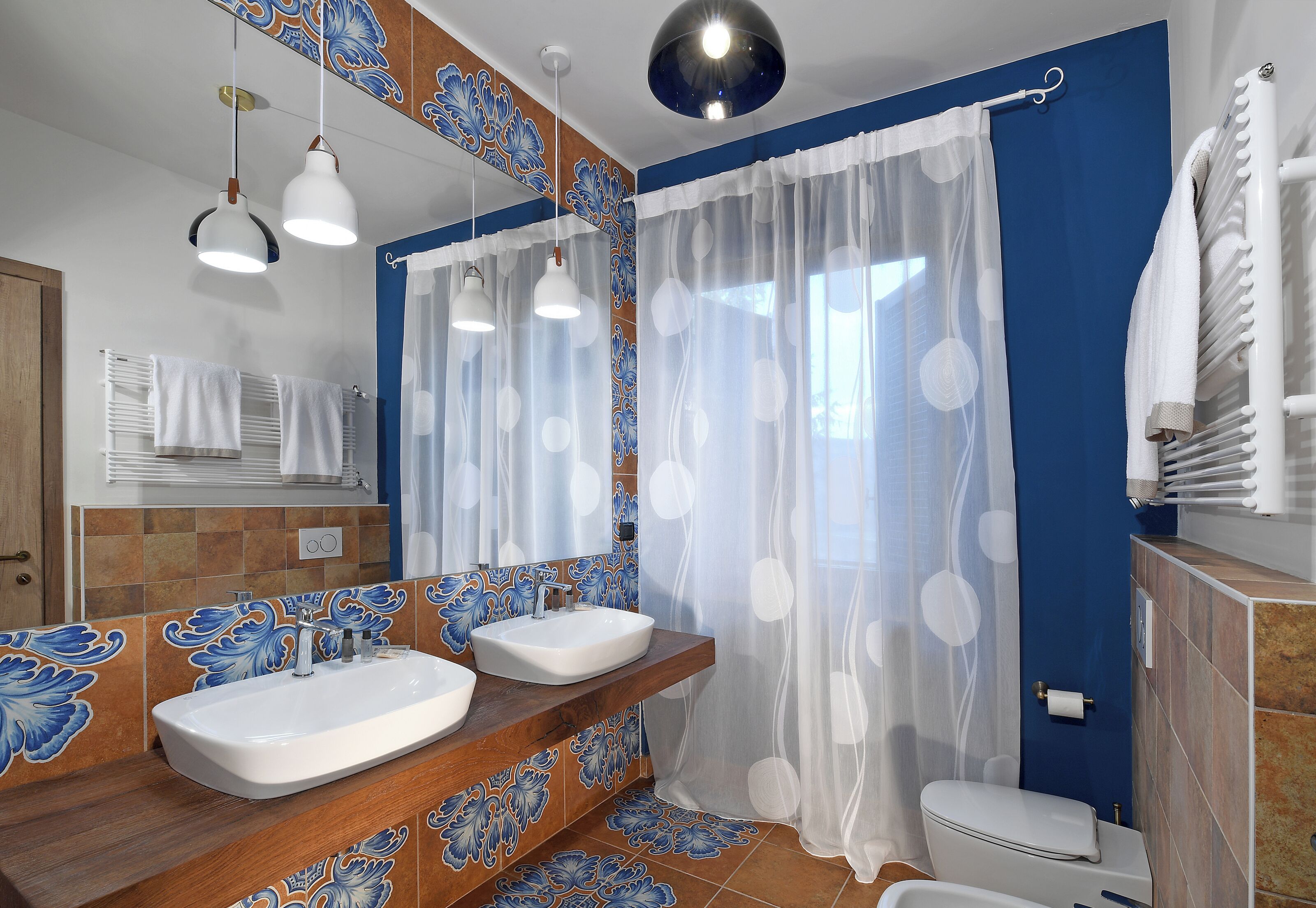 A bathroom with two sinks, a toilet, and a shower curtain.