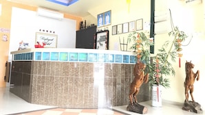 A hotel reception area with a tiled floor, a reception desk, a framed sign, and a red lantern. - Rafayeh Hotel (Seremban)
