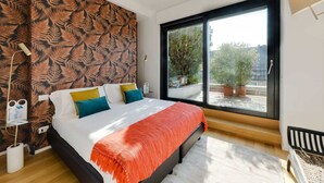 Una camera da letto moderna con un letto grande, una finestra vista sul verde e un muro decorato.