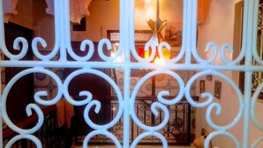 A room with ornate white metal railings, a decorative vase, and a patterned wall. - Hostel Dream Belko (Marrakech)