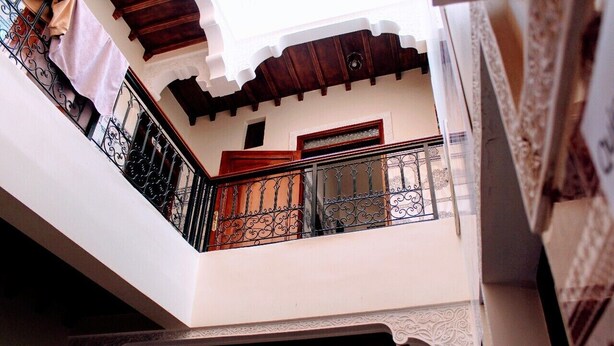 A balcony with ornate wrought iron railings and a wooden ceiling. - Hostel Dream Belko (Marrakech)