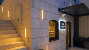 A hotel entrance with a modern design, featuring a staircase leading to the main building, a signboard, and a well-lit pathway. - Sana Hotel Sarajevo (Sarajevo)