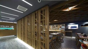 A modern hotel lobby with a reception desk, a bar area, and a seating area with tables and chairs. - Sana Hotel Sarajevo (Sarajevo)